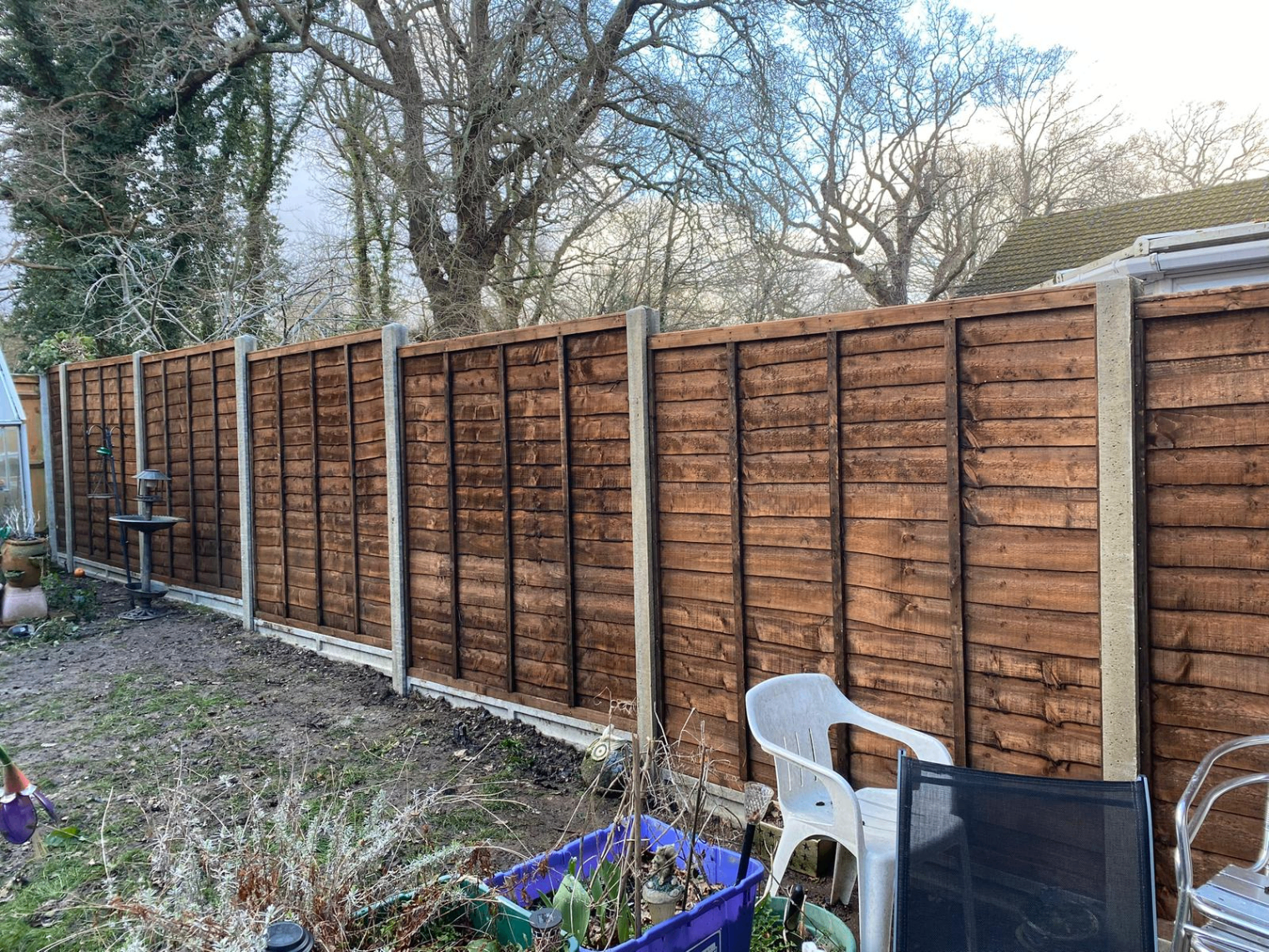 Long run of waney lap fence panels with concrete posts