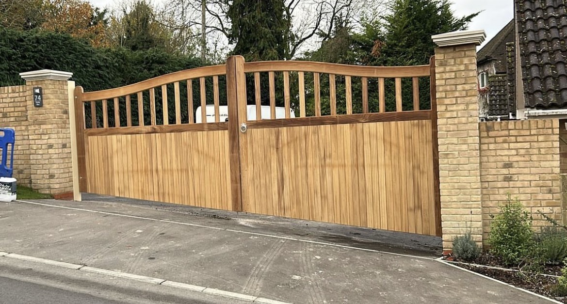 Bespoke hardwood driveway gates between brick piers