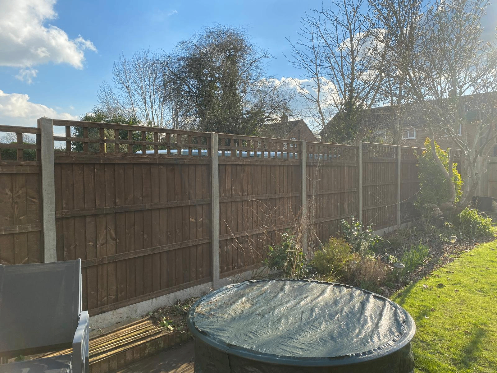 Closeboard fence with trellis top behind patio