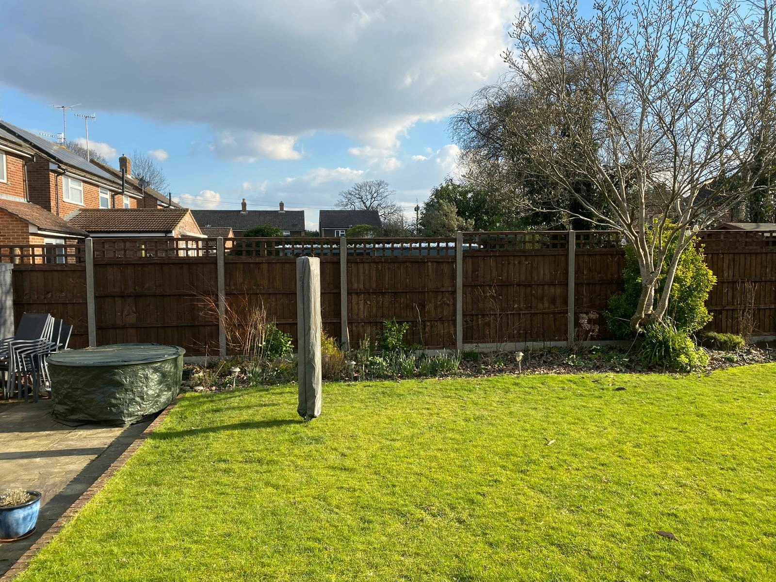 Trellis-topped fence line along a lawn